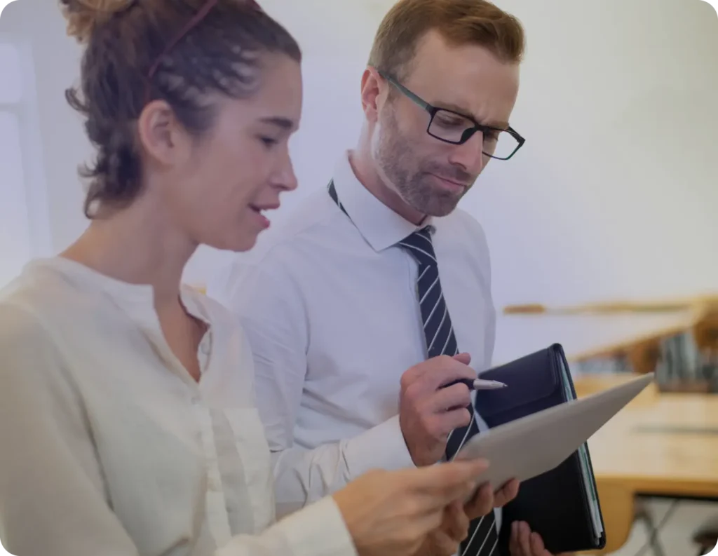 Business woman showing something on tablet screen to thoughtful male colleague